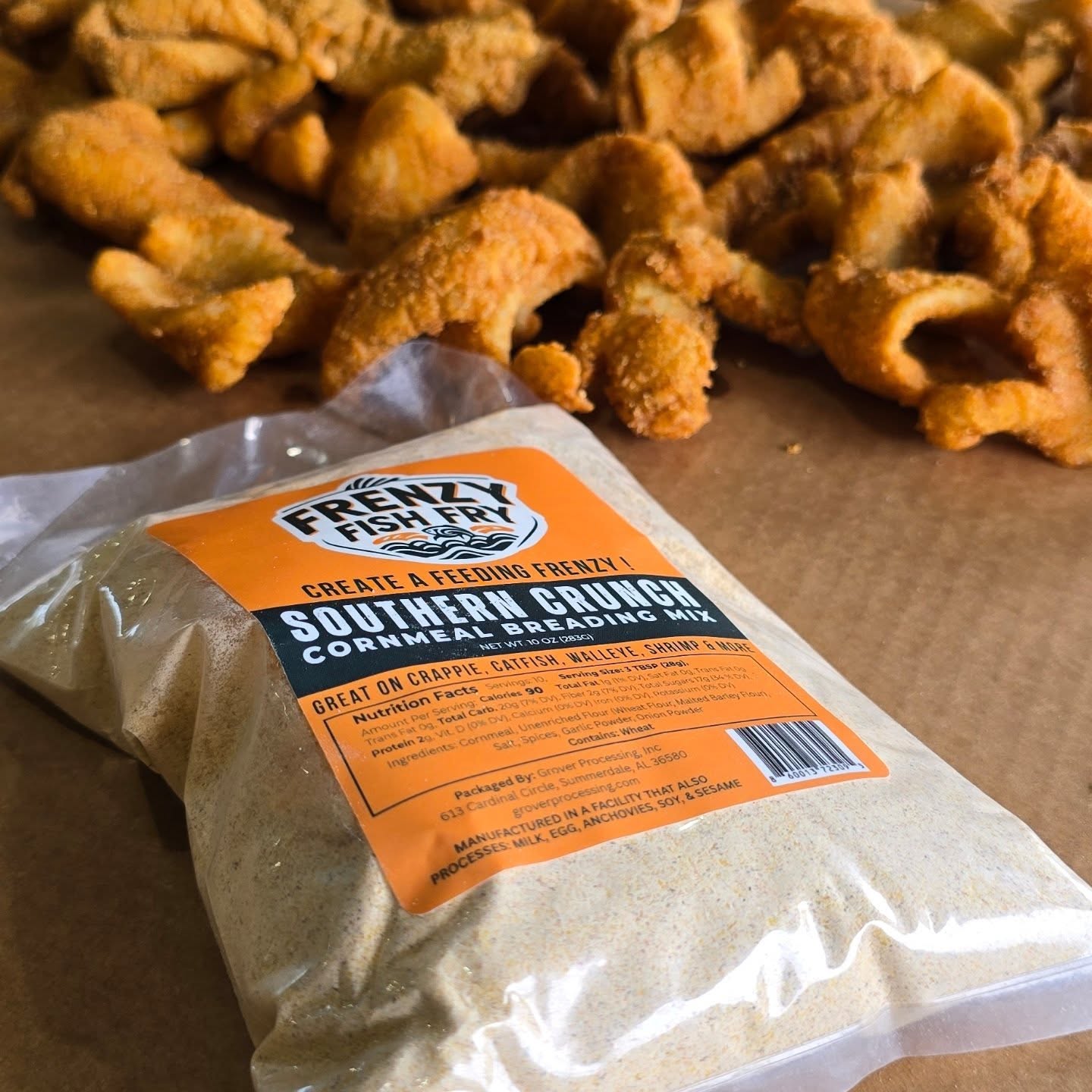 Frenzy Fish Fry Southern Crunch breading mix bag on table with fresh fish in the background, perfect for frying walleye, catfish, or crappie